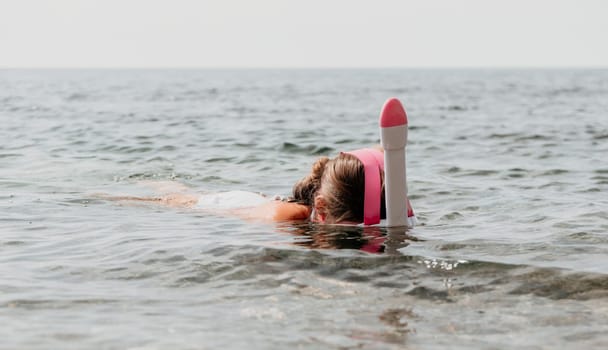 Young happy woman in white bikini put pink snorkeling mask on beach before swimming. girl having fun relaxing on beautiful beach. Beach lifestyle