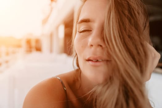 Happy woman portrait in cafe. Boho chic fashion style. Outdoor photo of young happy woman with long hair, sunny weather outdoors sitting in modern cafe