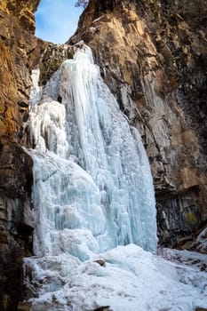 Picturesque frozen Butakovsky waterfall in the rock in the Butakovsky gorge in the Ile Alatau National Natural Park in the Tien Shan Mountains of Almaty in Kazakhstan.