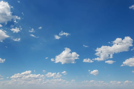 Electric blue sky with fluffy white cumulus clouds.