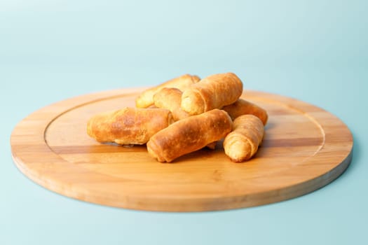 Dessert bagels on a wooden tray on a blue background. Sweet pastries for tea.