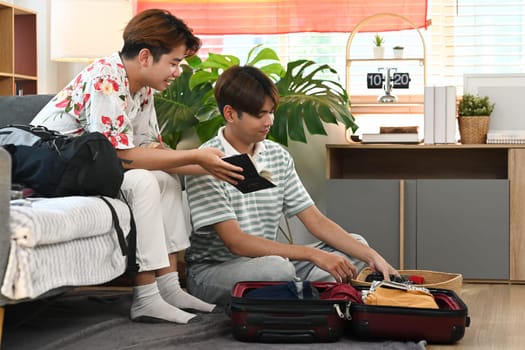 Young gay couple checking packing list before their summer vacation trip.