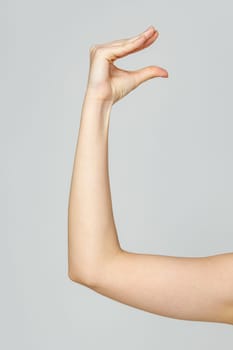 Young Woman Arm with Gesture close up on gray background