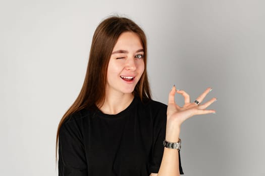 Young Woman Making OK Sign With Fingers in Studio