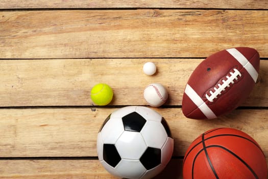 Different sports equipment on wooden background top view photo