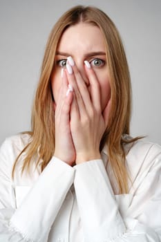 Young Woman in White Blouse Expressing Concern in studio close up