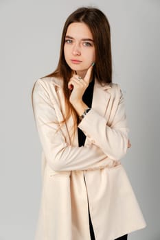 Young Woman In Black Shirt Pondering a Thought Against a Gray Backdrop close up