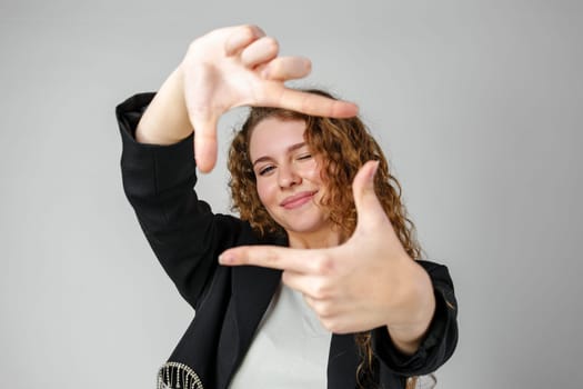 Woman Making Hand Gesture Picture Frame in Studio close up