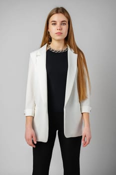 Woman in Black Top and White Jacket Posing in Studio close up