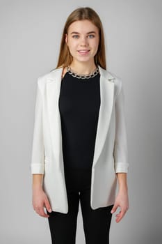 Woman in Black Top and White Jacket Posing in Studio close up