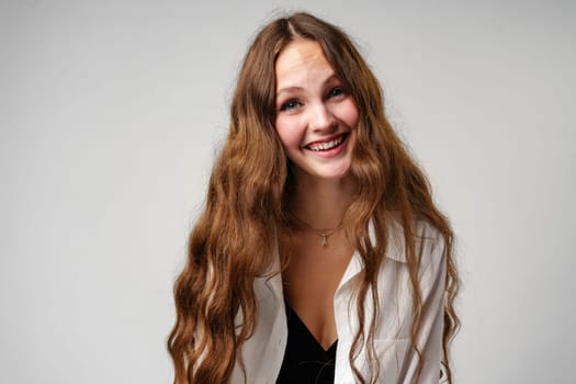 A woman with vibrant, long red hair is smiling directly at the camera. Her expression exudes joy and confidence as she poses for the photograph.