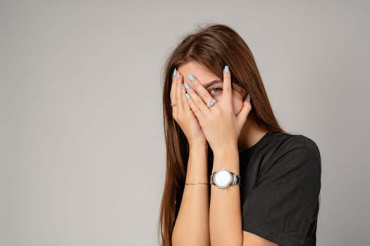 Young Woman Covering Face With Hands in Studio close up