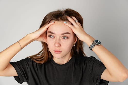 Young Woman Holding Head in Hands because of headache close up