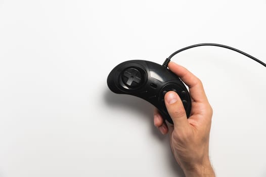 Black retro joystick on a white background in a man's hand. View from above.