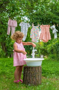 The child washes clothes and toys. Selective focus. Kid.