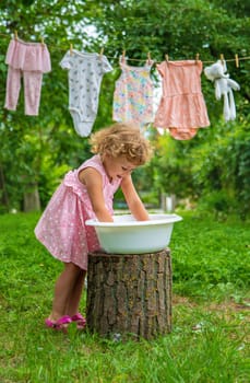 The child washes clothes and toys. Selective focus. Kid.