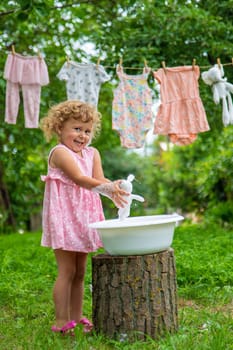 The child washes clothes and toys. Selective focus. Kid.