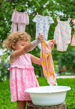 The child washes clothes and toys. Selective focus. Kid.