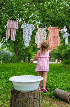 The child washes clothes and toys. Selective focus. Kid.