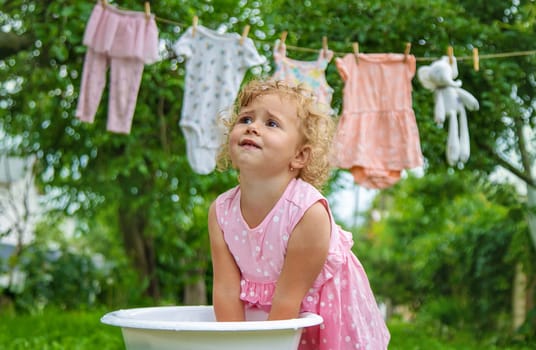 The child washes clothes and toys. Selective focus. Kid.