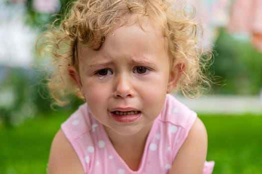 Child girl crying in the park. Selective focus. Kid.