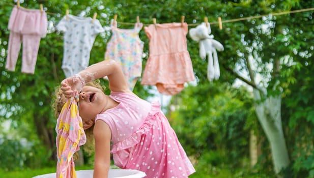 The child washes clothes and toys. Selective focus. Kid.