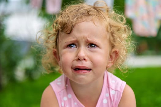 Child girl crying in the park. Selective focus. Kid.