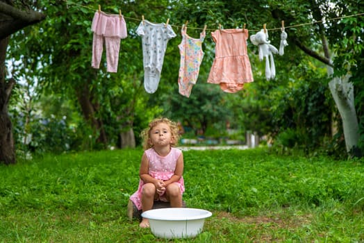 The child washes clothes and toys. Selective focus. Kid.