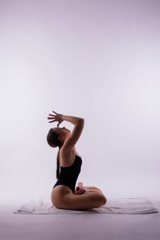 Young beautiful yoga female posing on studio background