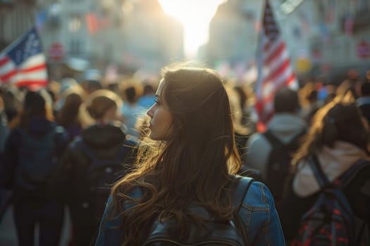 A young attractive girl in a crowd of people with American flags in her hands.