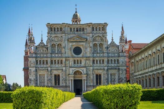 Certosa di Pavia monastery, historical monumental complex that includes a monastery and a sanctuary. green court and a church.The Ducale Palace on the right,Pavia,Italy.