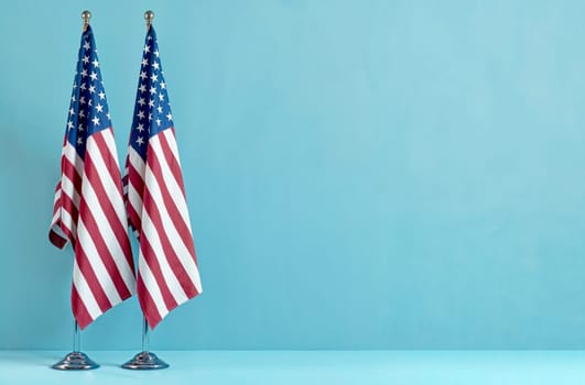 Two USA flags on blue background, space for text