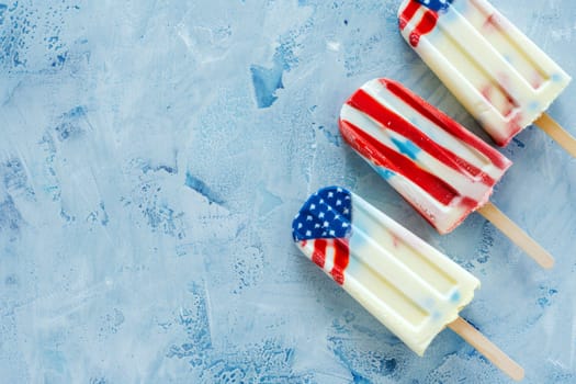 American flag-decorated popsicles on a blue backdrop, perfect for national celebrations.