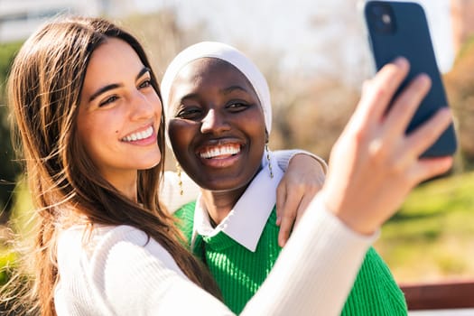 two young female friends smiling happy while taking selfie photo with mobile phone, concept of friendship and modern lifestyle