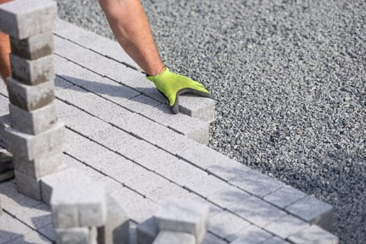 Process of building sidewalk, a aworker laying interlocking walking path, industrial concept