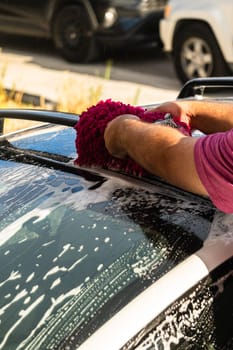 Efficiently cleaning an electric car in the comfort of a suburban driveway, combining eco-consciousness with practicality.