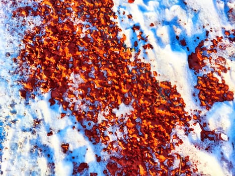 Red pebbles or rubberized textured material and white snow on it. Background, texture, frame, copy space. Contrast of red pebbles and white snow creating textured backdrop