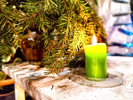 Candle burning amidst holiday decorations. Festive Candles Lighting Up Christmas-Adorned Room at Night