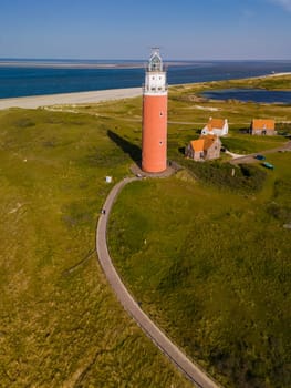 A stunning aerial view of a lighthouse standing tall near the ocean, surrounded by vast blue waters and endless skies, offering guidance and safety to passing ships.