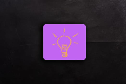 Idea in the form of a light bulb on pink note paper. High quality photo