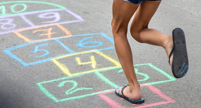 Children play hopscotch on the street. Selective focus. Nature.