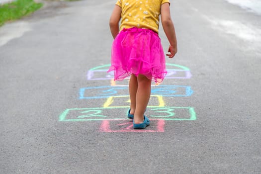 Children play hopscotch on the street. Selective focus. Nature.