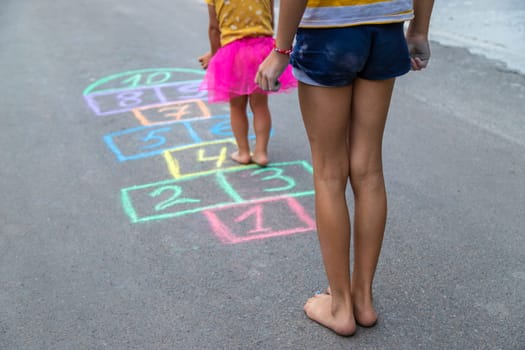 Children play hopscotch on the street. Selective focus. Nature.