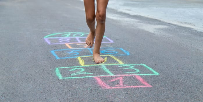 Children play hopscotch on the street. Selective focus. Nature.