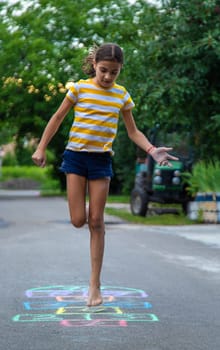 Children play hopscotch on the street. Selective focus. Nature.