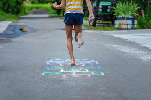 Children play hopscotch on the street. Selective focus. Nature.