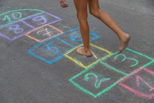 Children play hopscotch on the street. Selective focus. Nature.