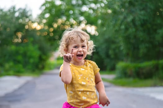 A child points his finger at a portrait on the street. Selective focus. Kid.