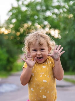 Cheerful child on the street portrait. Selective focus. Kid.