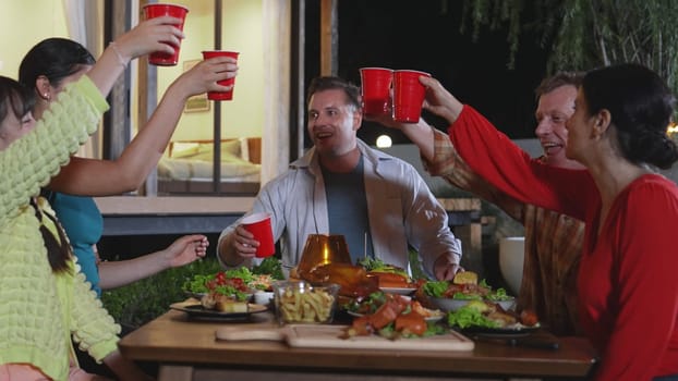 Family together celebrate holiday in garden. Grandparents, parents and daughter use beverage glass cheers for celebration. Outdoor camping activity relax with meal strengthen family bond. Divergence.